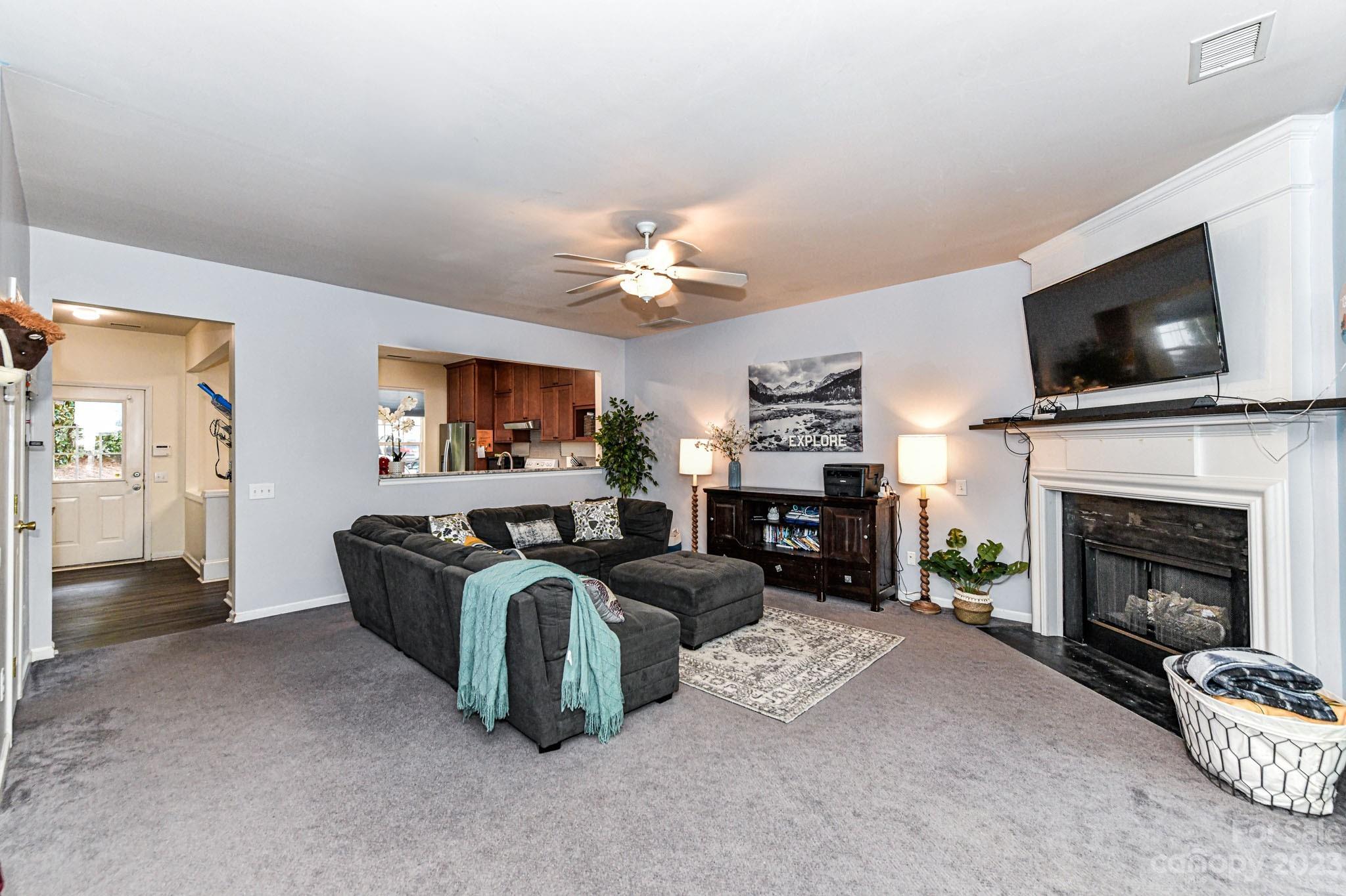 6991 Rothchild Drive Charlotte, NC 28270 - Photo 9 of 37 a living room with furniture a fireplace and a flat screen tv
