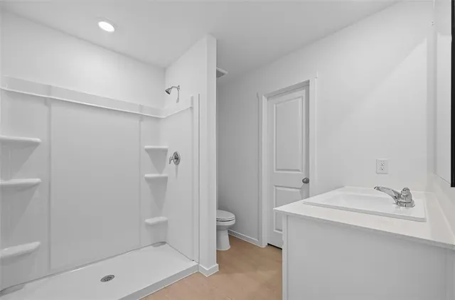 a bathroom with a sink a toilet and shower