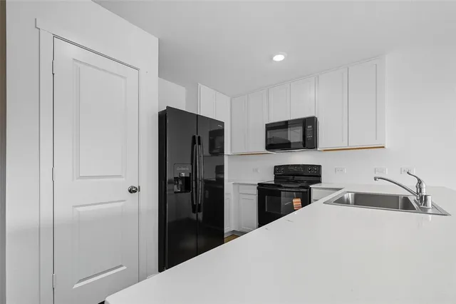 a kitchen with refrigerator a microwave a sink and cabinets