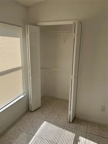 an empty room with a ceiling fan and carpet
