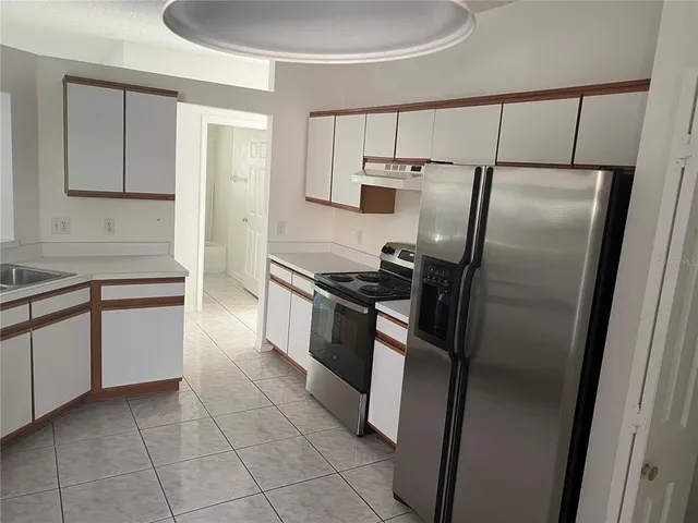 a kitchen with a refrigerator sink and cabinets