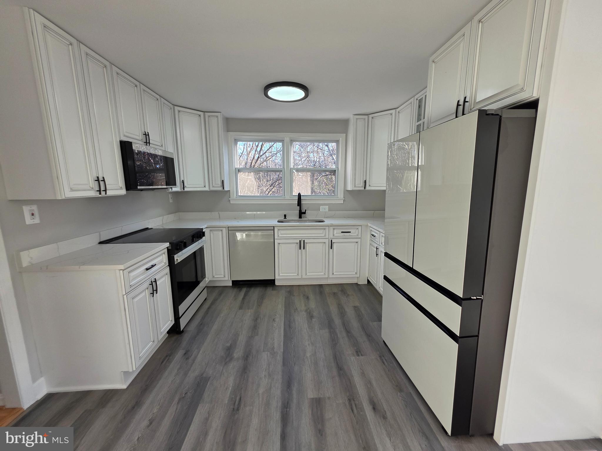 25294 Vista Road Hollywood, MD 20636 - Photo 24 of 53 a kitchen with a sink a refrigerator a window and cabinets
