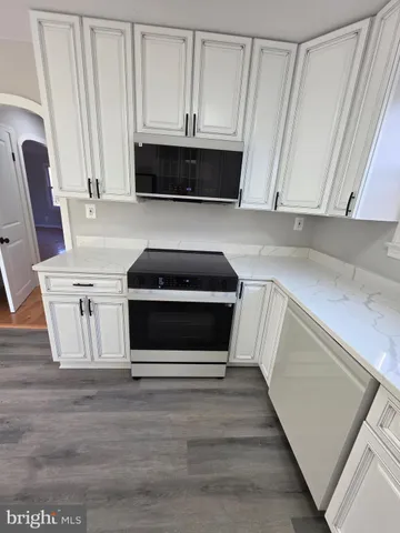 a kitchen with granite countertop a refrigerator and a stove