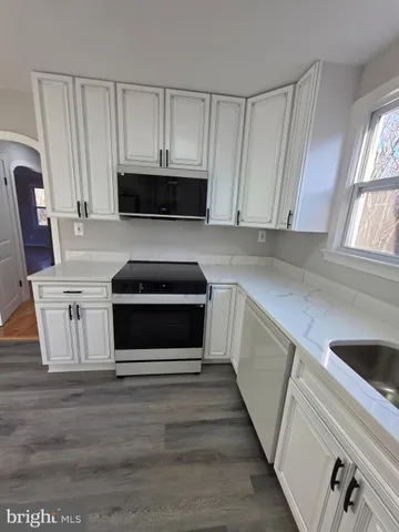 a kitchen with white cabinets and stainless steel appliances