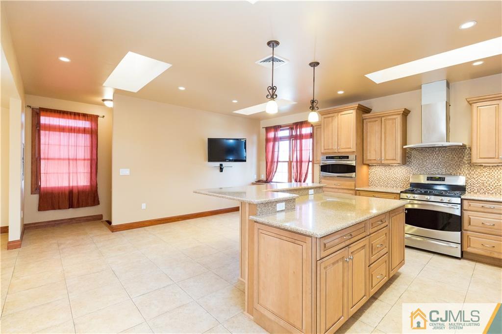 19 Bodnarik Road Edison, NJ 08837 - Photo 14 of 50 a kitchen with stainless steel appliances granite countertop a sink and a stove