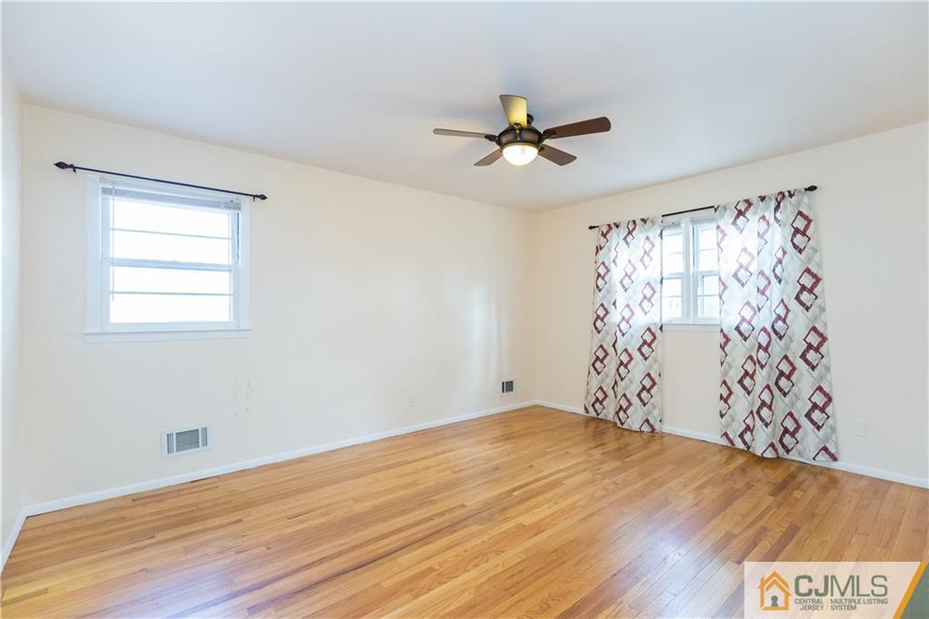 19 Bodnarik Road Edison, NJ 08837 - Photo 23 of 50 a view of empty room with wooden floor and fan