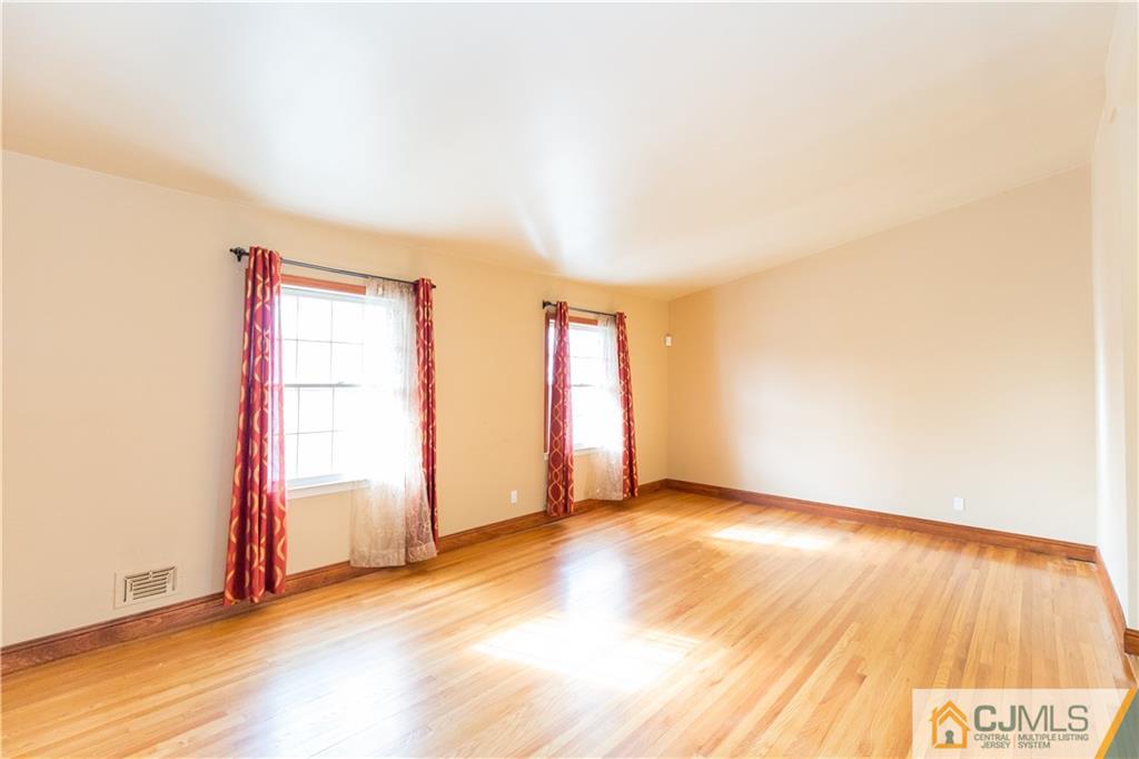 19 Bodnarik Road Edison, NJ 08837 - Photo 5 of 50 a view of an empty room with wooden floor and a window