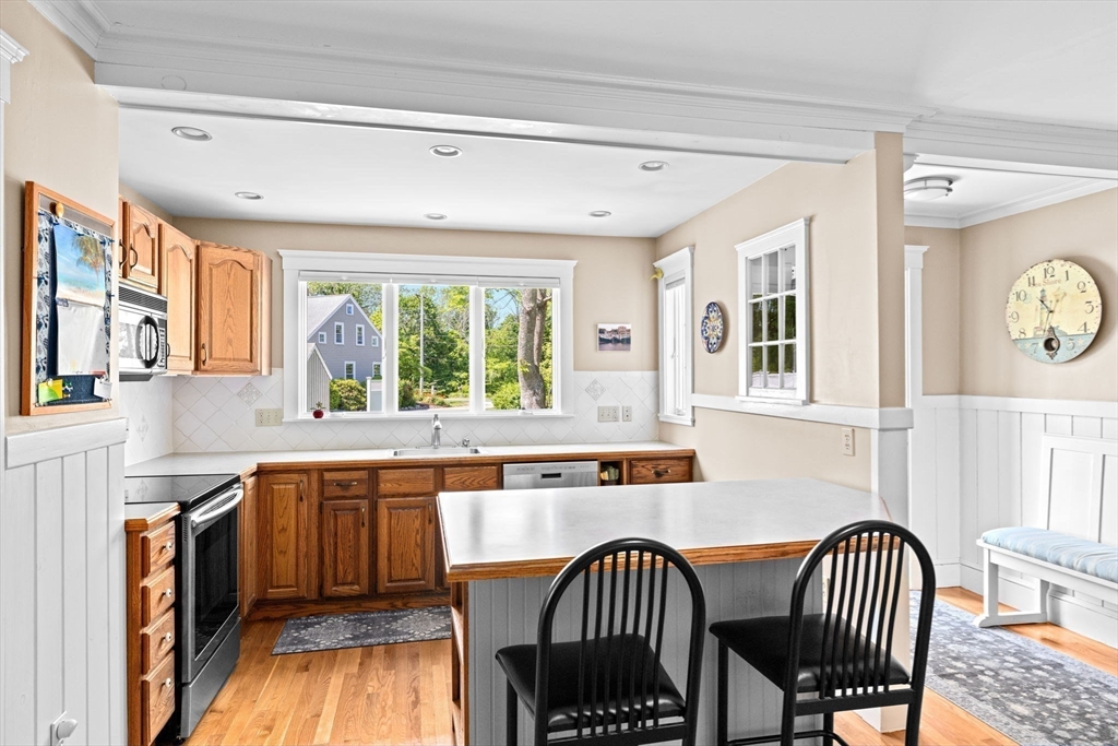 157 Branch Street Scituate, MA 02066 - Photo 14 of 41 a kitchen with stainless steel appliances granite countertop a stove a sink a dining table and chairs