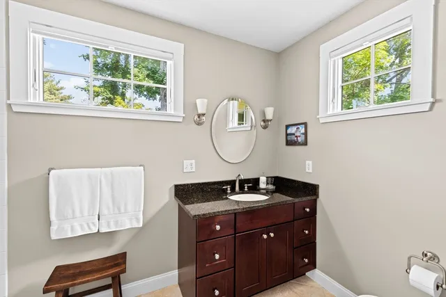 a bathroom with a sink mirror and window