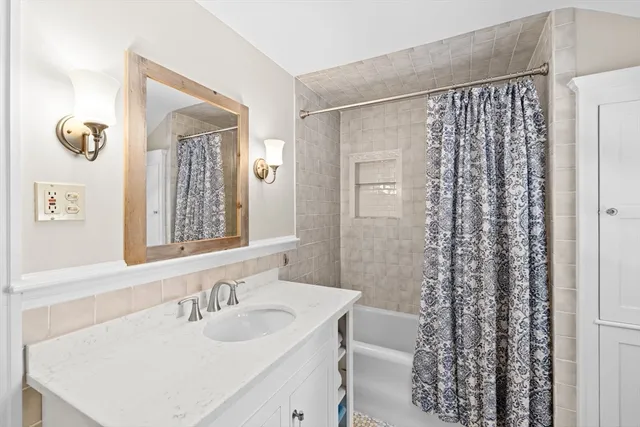 a bathroom with a sink a mirror a vanity and a shower