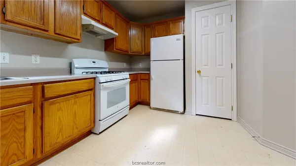 a kitchen with stainless steel appliances granite countertop a refrigerator a stove and a sink