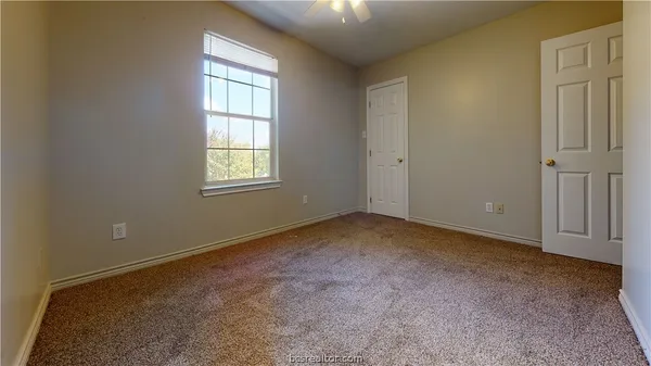an empty room with windows and closet