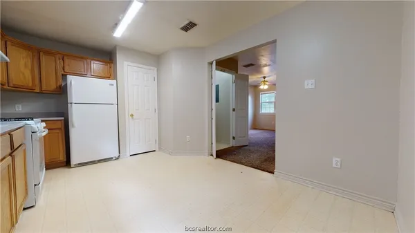 a view of a kitchen with a refrigerator and cabinets