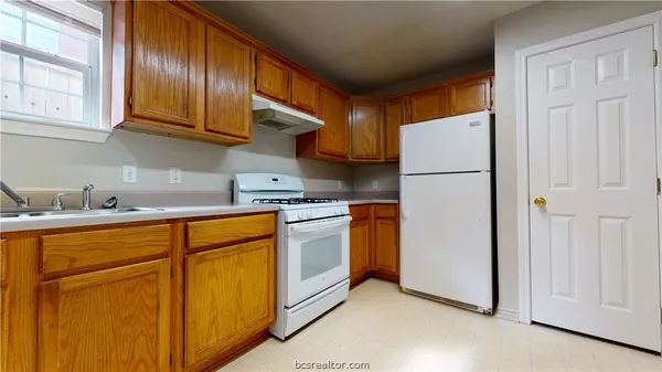 a kitchen with stainless steel appliances granite countertop a refrigerator a sink and cabinets