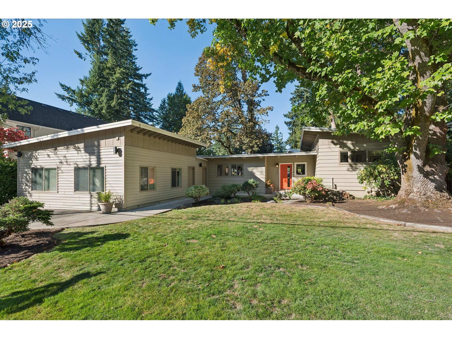 a front view of house with yard and trees in the background