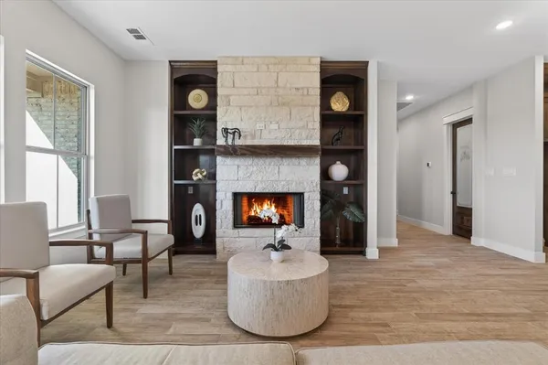 a living room with furniture a fireplace and a chandelier