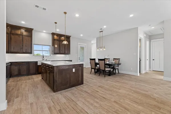 a kitchen with a sink cabinets and wooden floor
