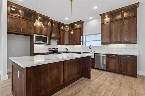 a kitchen with stainless steel appliances granite countertop a sink and a stove top oven