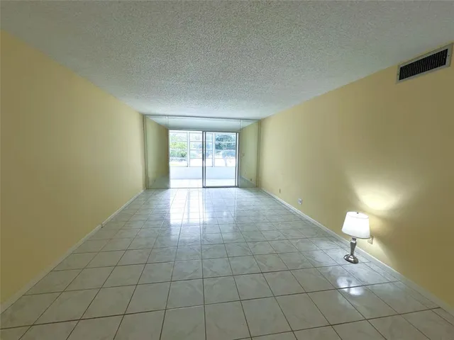 a living room with a sink and a stove with wooden floor