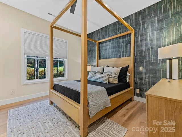 a bedroom with a bed and a dresser next to a window