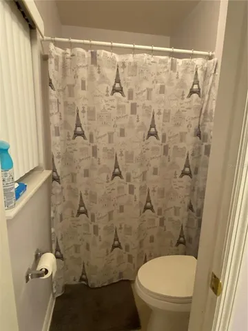 a white toilet sitting next to a shower curtain