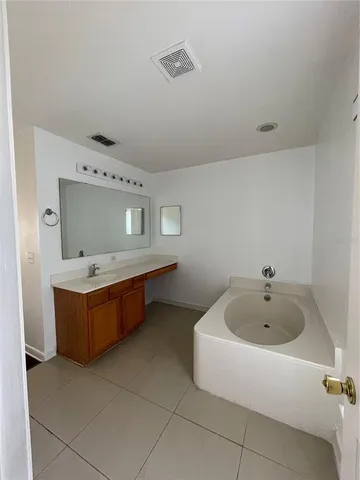 a bathroom with a tub sink and mirror