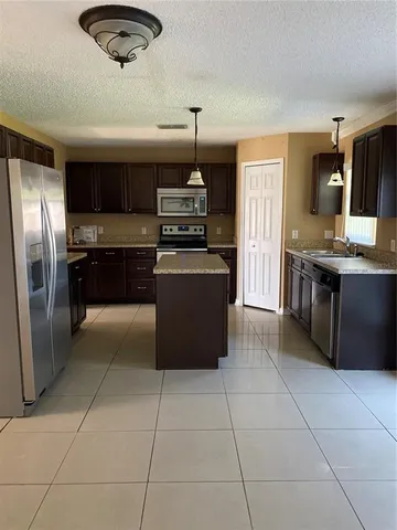 a kitchen with stainless steel appliances granite countertop a stove a refrigerator and a sink