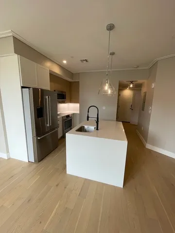 a view of a kitchen with a sink and refrigerator