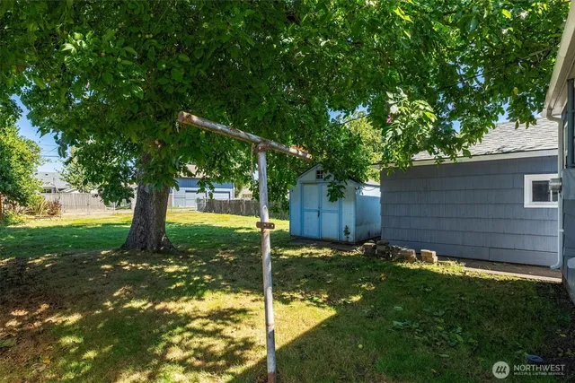 a view of backyard with a barn and large trees