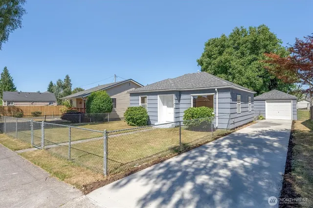 a view of a house with backyard and a tree