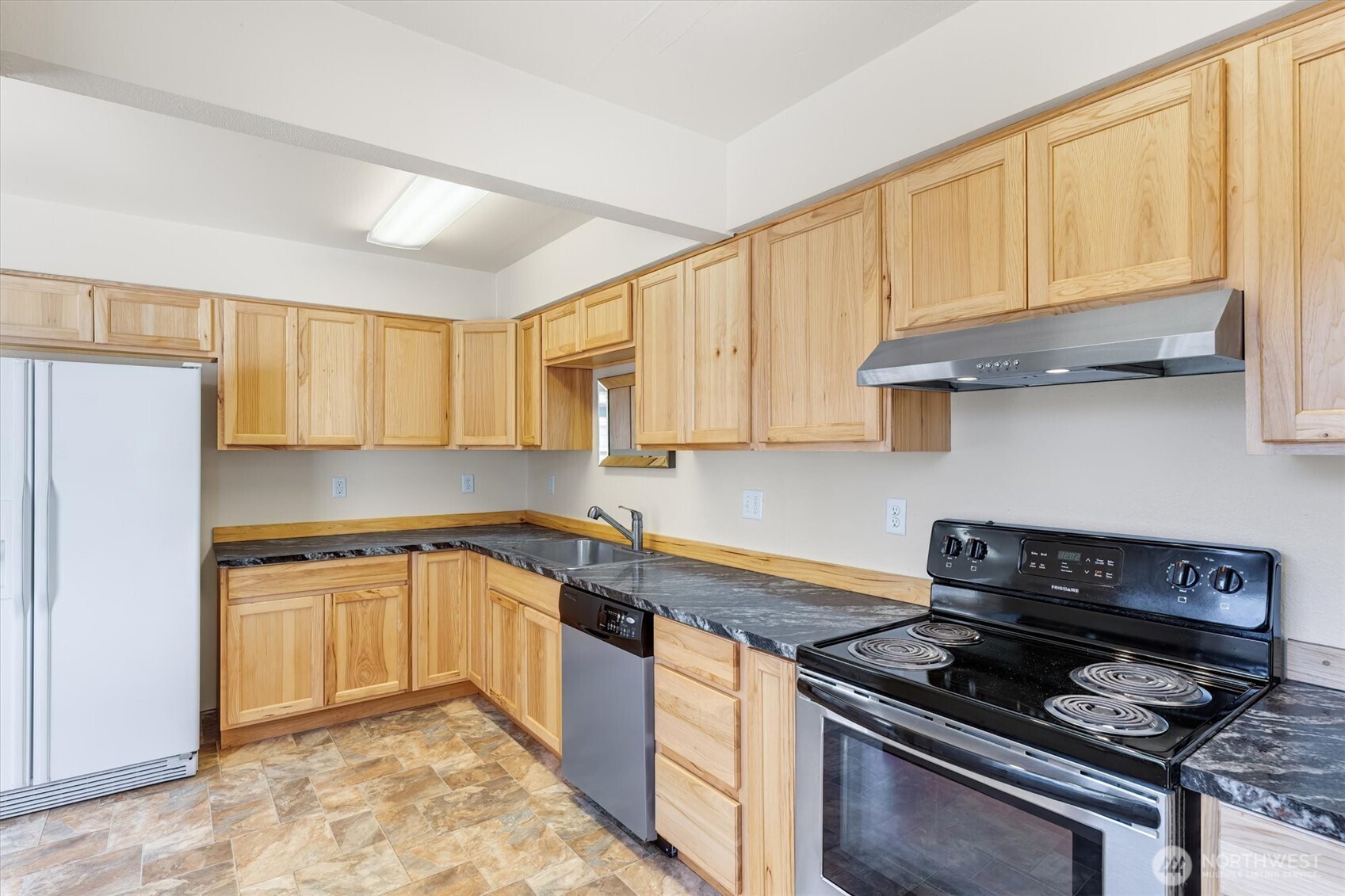 2938 Washington Way Longview, WA 98632 - Photo 10 of 21 a kitchen with granite countertop wooden cabinets and a stove top oven