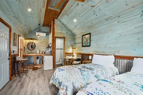 a bedroom with a bed and wooden floor