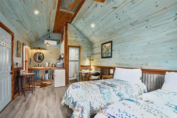 a bedroom with a bed and wooden floor