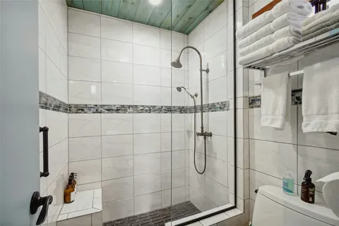 a view of a patio with table and chairs with wooden fence and large trees