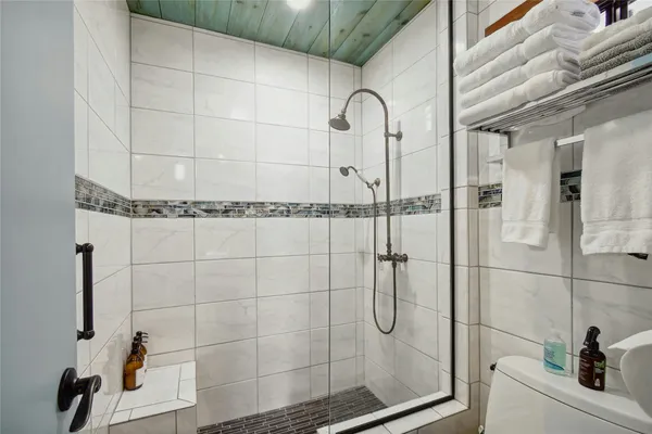 a view of a patio with table and chairs with wooden fence and large trees