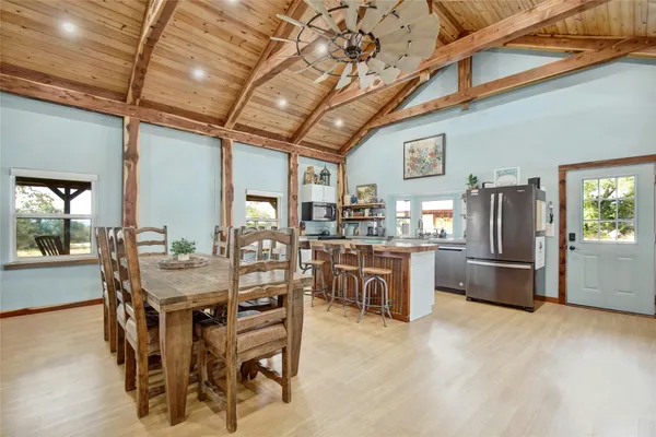 a kitchen with stainless steel appliances kitchen island granite countertop a table and chairs in it