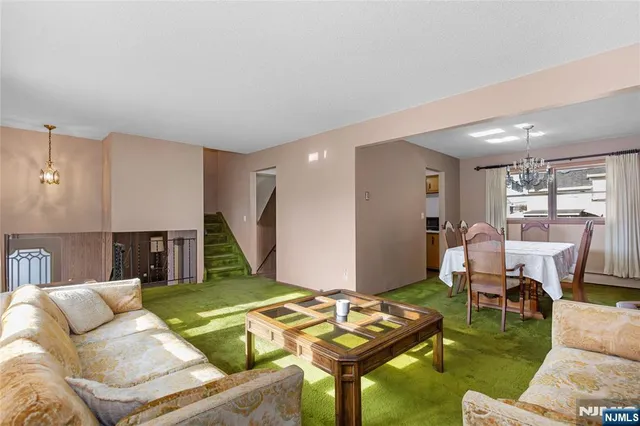 a kitchen with stainless steel appliances granite countertop a refrigerator a sink dishwasher a stove and a dining table with wooden floor