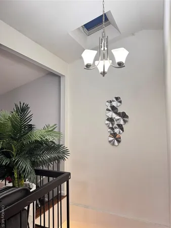 a view of a room with a chandelier fan and wooden floor