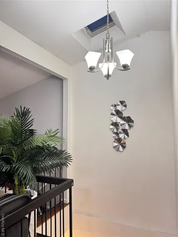 a view of a room with a chandelier fan and wooden floor