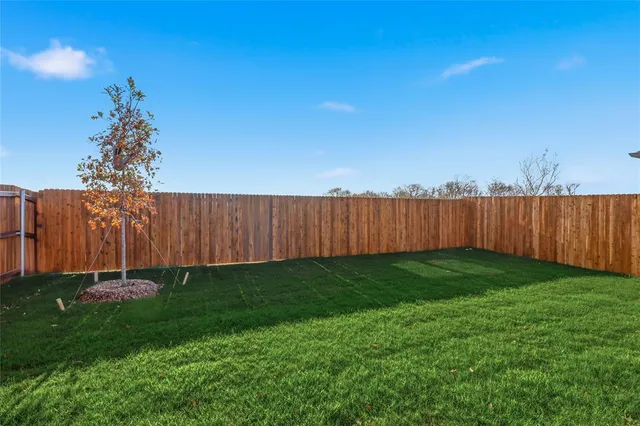 a view of a backyard with wooden fence