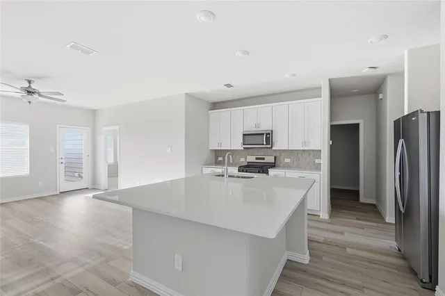 a kitchen with stainless steel appliances a refrigerator sink and stove