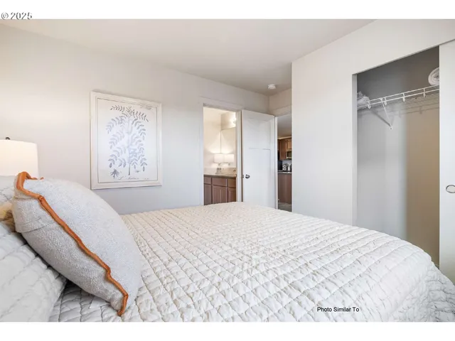 a bedroom with a large bed and a window