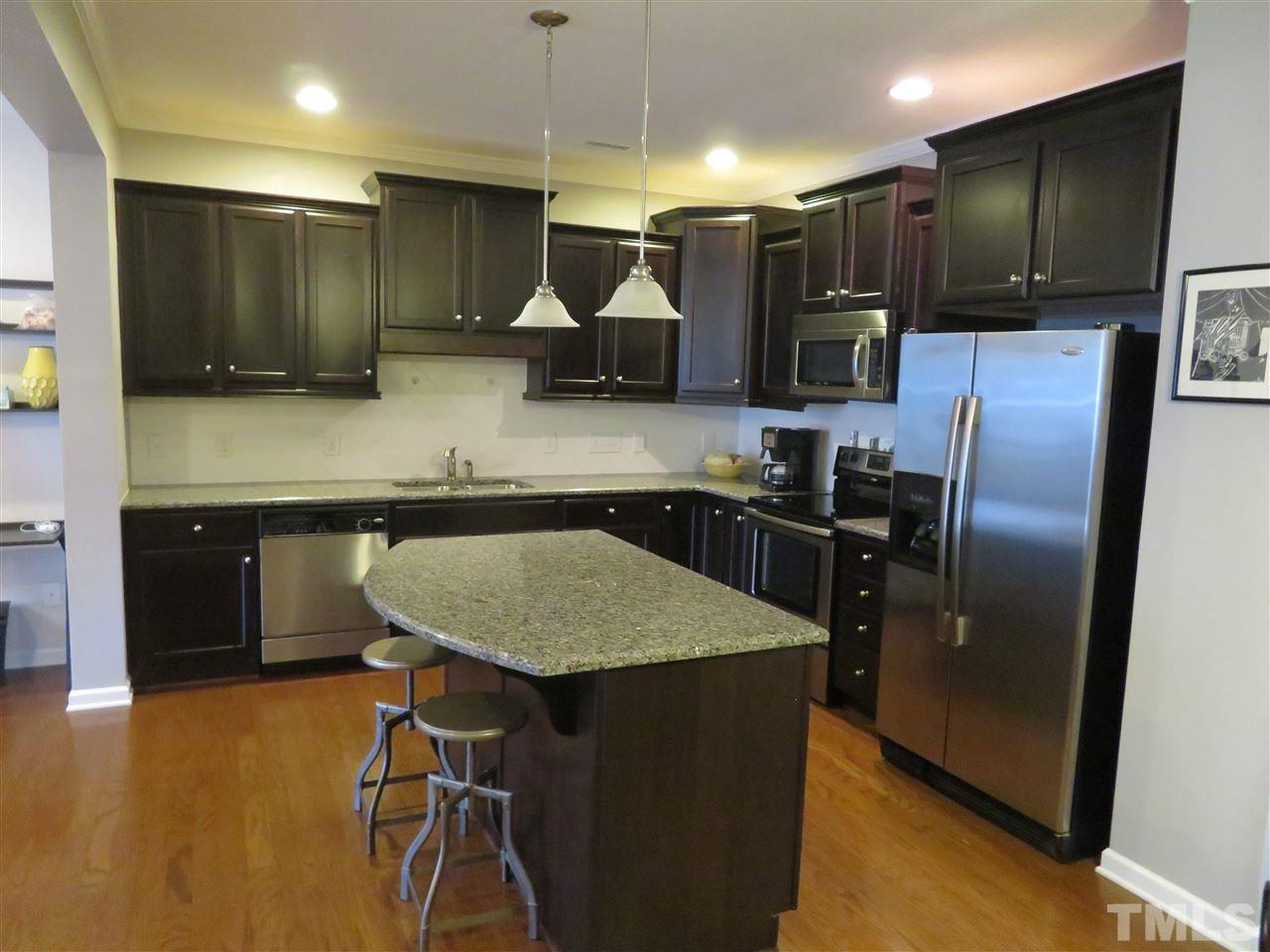 2442 Memory Ridge Drive Raleigh, NC 27606 - Photo 13 of 23 a kitchen with kitchen island a counter top space cabinets and stainless steel appliances