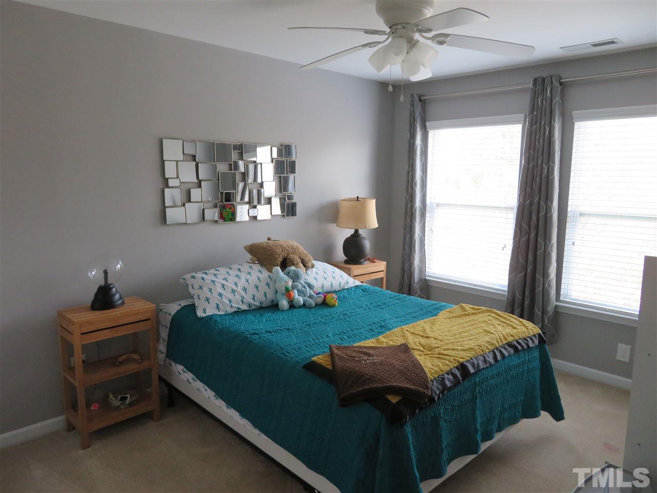 2442 Memory Ridge Drive Raleigh, NC 27606 - Photo 19 of 23 a bedroom with a bed and a chandelier fan