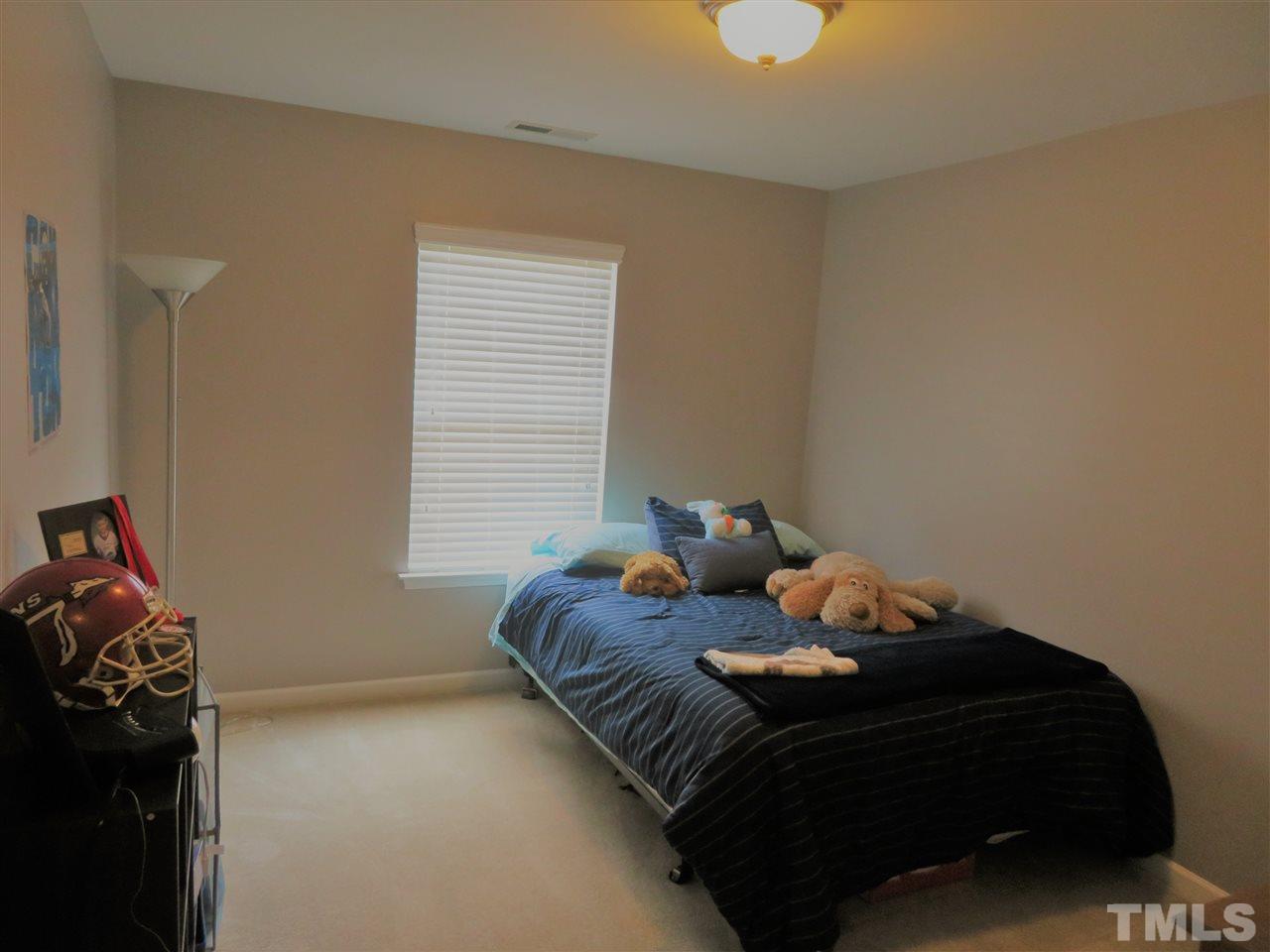 2442 Memory Ridge Drive Raleigh, NC 27606 - Photo 20 of 23 a bed sitting in a bedroom next to a window