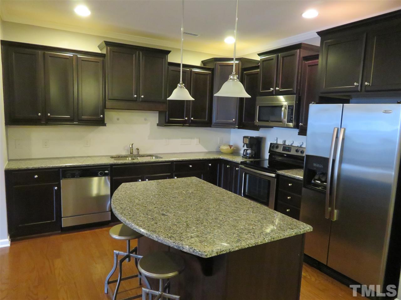 2442 Memory Ridge Drive Raleigh, NC 27606 - Photo 6 of 23 a kitchen with stainless steel appliances wooden cabinets sink and stove