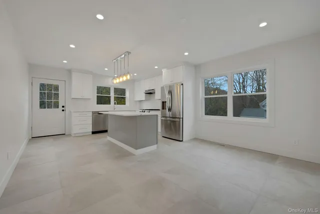 a view of a kitchen with a sink an oven a refrigerator and window