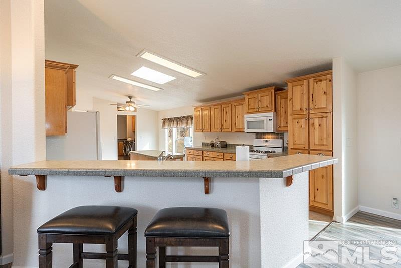 3745 Schindler Road Fallon, NV 89406 - Photo 4 of 16 a kitchen with stainless steel appliances granite countertop a sink and chairs in it