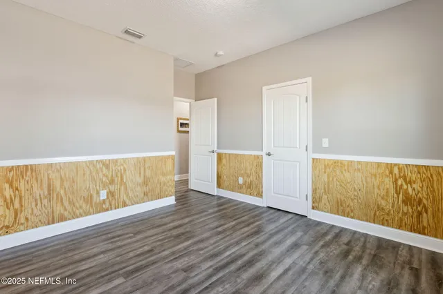 a view of an empty room with wooden floor