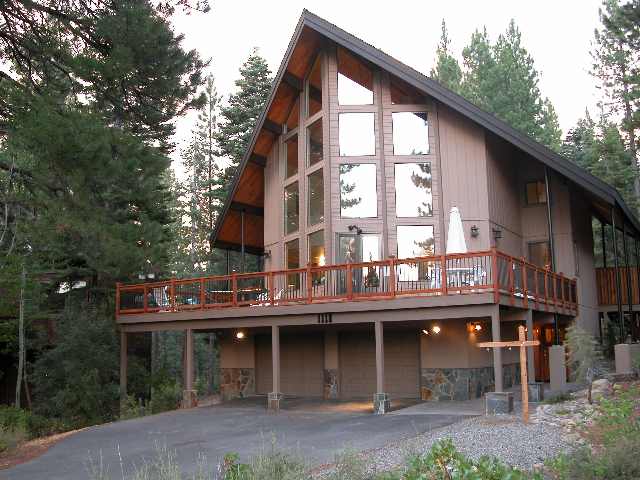 a front view of a building with many windows and a yard